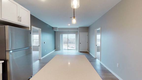 A kitchen with a refrigerator, cabinets, and a countertop.