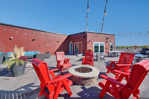 A red patio with chairs and a fire pit.