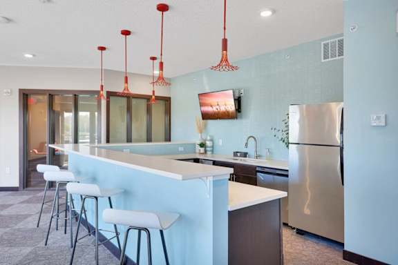 A kitchen with a blue wall and a stainless steel refrigerator.