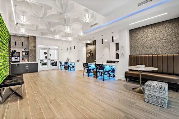 A modern dining area with a green wall and wooden floors.