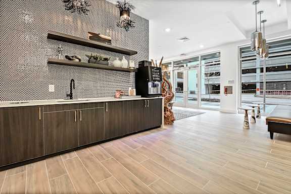 A modern kitchen with a dark wood floor and a black counter top.