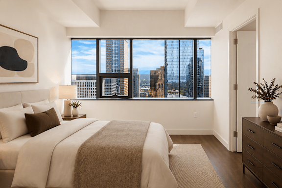 A bedroom with a large bed and a view of the city.