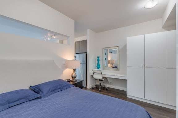 a bedroom with a large bed and a desk with a chair
