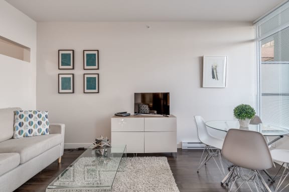 a living room with white walls and a glass coffee table