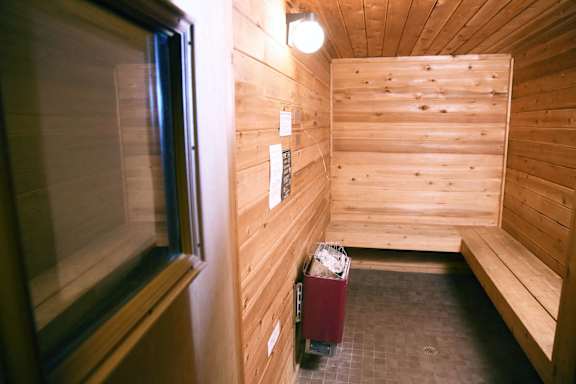 A sauna with wood panel walls and red sauna heater at Graymayre Crossing Apartments, Spokane, WA, 99208