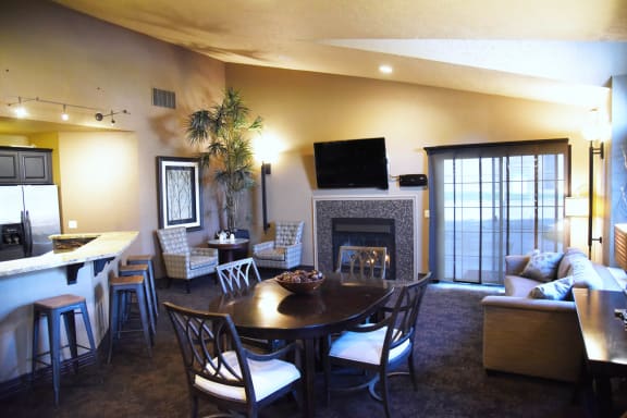 A living room with a fireplace and a dining table at Graymayre Crossing Apartments, Spokane, WA, 99208