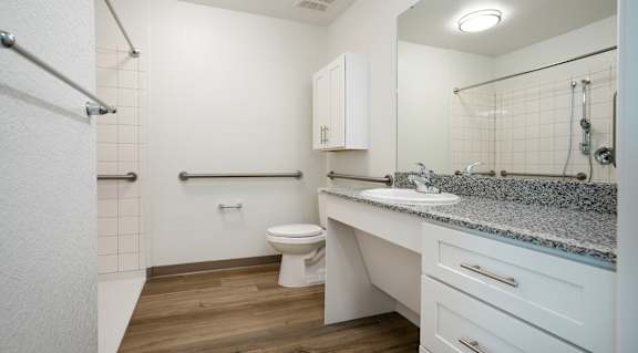 A bathroom with a toilet, sink, and a shower.
