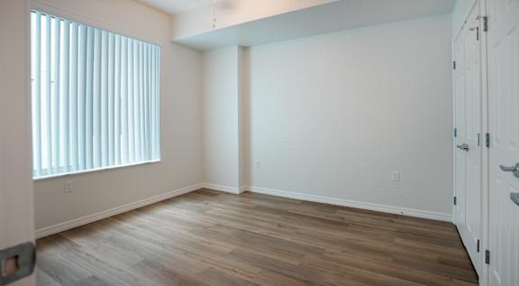 A room with wooden flooring and white walls.