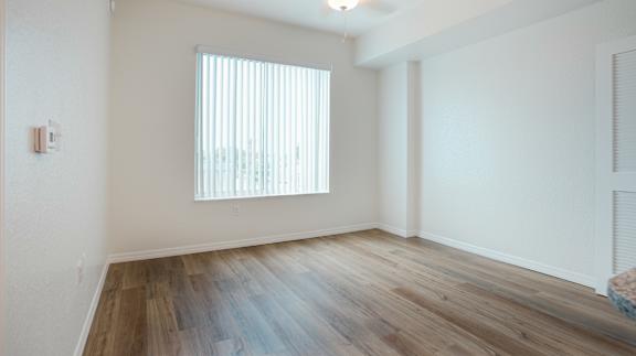 A room with a window and wooden flooring.