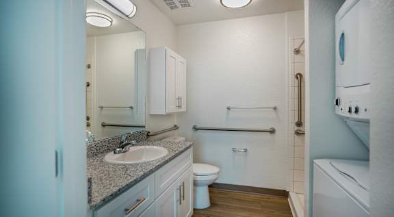 A bathroom with a toilet, sink, and mirror.