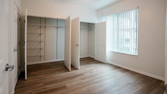 A room with a white door and a wooden floor.