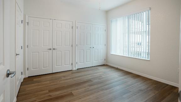 A room with white doors and a window with blinds.