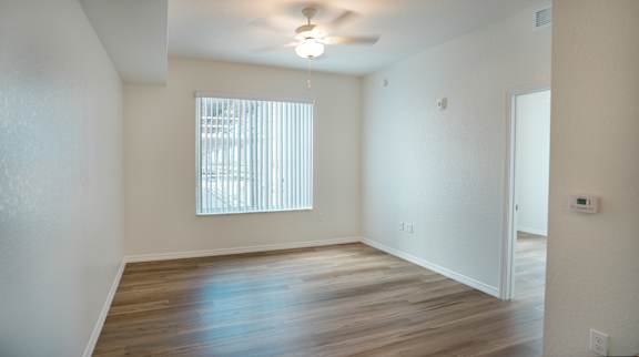 A room with a window and wooden floors.