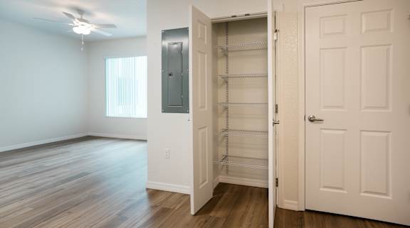 A room with a white door and a window with blinds.
