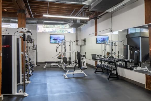 a workout room with weights and machines in a gym