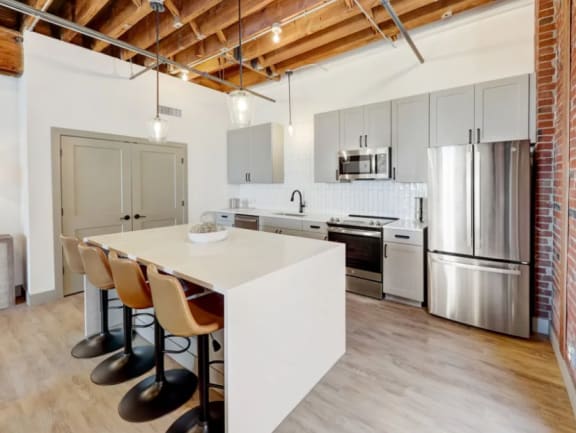 a kitchen with a white island and a stainless steel refrigerator