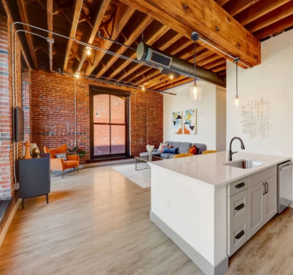 a kitchen and living room in a loft with exposed ceilings