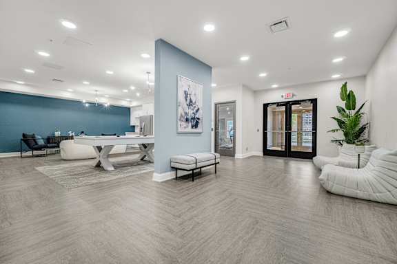 A spacious room with a blue accent wall and a white chair at Park Lamont Townhomes Apartments, Cleveland 44106