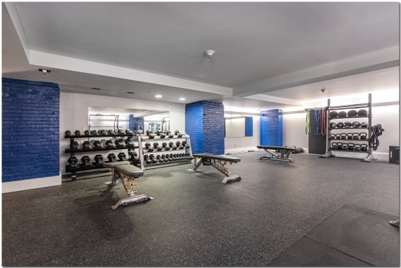 a spacious fitness room with weights and other exercise equipment