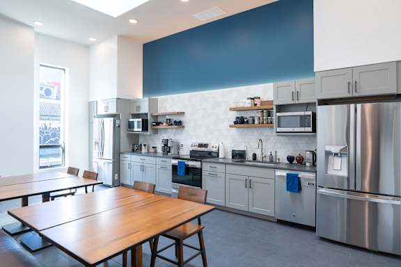 A modern kitchen with a wooden table and stainless steel appliances at Life At Agora Apartments, Cleveland 44103