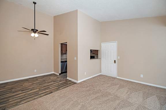 A room with a ceiling fan and a door.