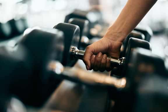 A person's hand is holding a dumbbell in a gym at Life At Agora, Cleveland