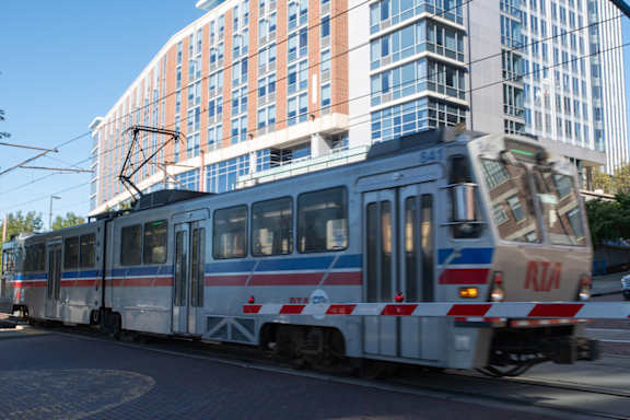A train with the letters RTA on the front is on a track at Life At Agora Apartments, Ohio, 44103