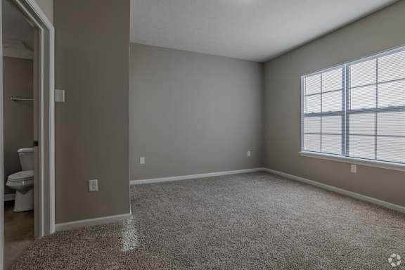 A room with a carpeted floor and a window with blinds.at The Residences at Akita Lane, Ohio, 43110
