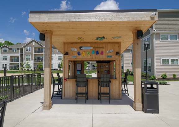 the covered patio has a bar with chairs at The Bend, Lancaster, OH
