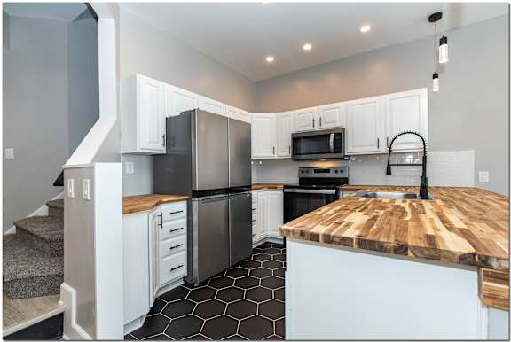 a kitchen with stainless steel appliances and a wooden counter top