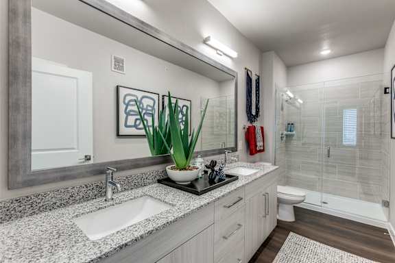 Elegant Bathrooms featuring Granite Countertops, Vanity Sconces and Glass Showers or Soaking Tubs at Cedar Heights Apartments in Southeast Austin TX