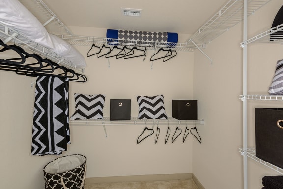 a walk in closet with white shelves and a white closet organizer with black and white zebra at Azura, Miami, FL