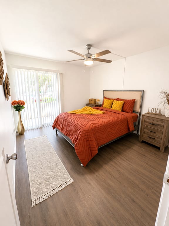 A bedroom with a bed, nightstand, and a rug.