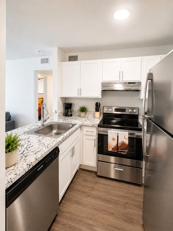 A modern kitchen with stainless steel appliances and white cabinets.