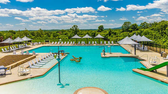 a large swimming pool with chairs and umbrellas