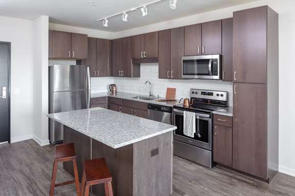 A kitchen with brown cabinets and a white island.