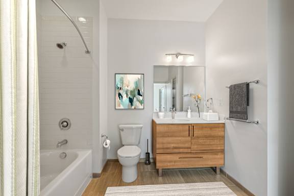 A bathroom with a white tub, toilet, and sink. at The Merc, Waltham