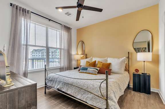 a bedroom with a bed and a ceiling fan
