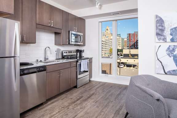 A modern kitchen with a view of the city outside the window.