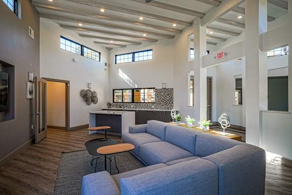 A living room with a grey couch and a round table.