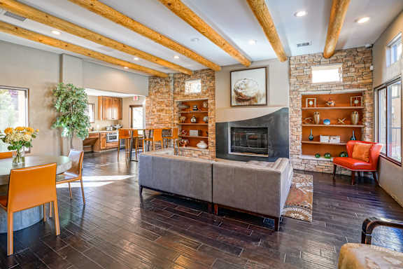 A living room with a stone fireplace and a large couch.
