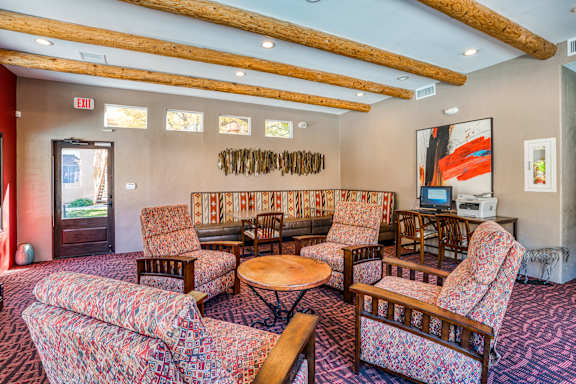 A room with a couch, chairs, and a table.