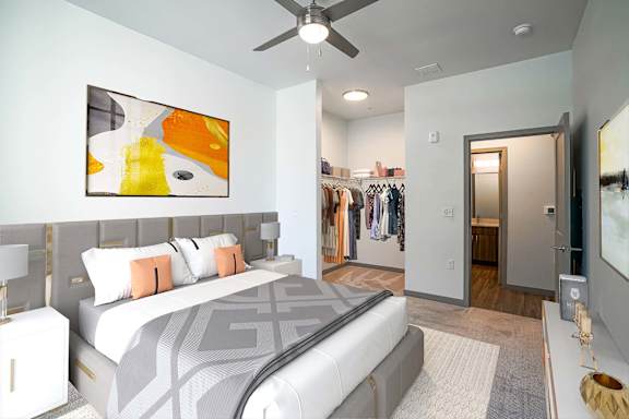 A bedroom with a large bed and a painting on the wall.