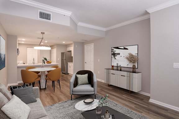 A modern living room with a grey sofa, a grey armchair, a white coffee table, and a grey rug at Floresta, Jupiter, FL