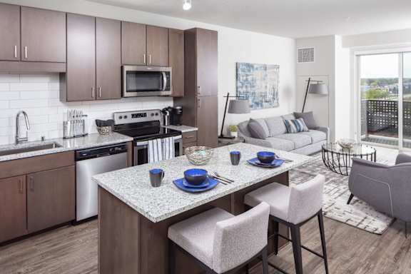 A modern kitchen with a dining table set for two.