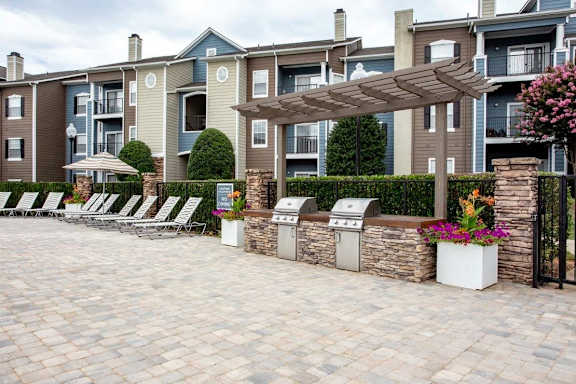 A patio area with a row of chairs and a canopy.