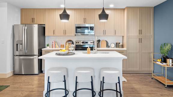 A modern kitchen with a white island and stainless steel appliances.
