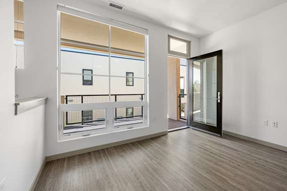 A room with a sliding glass door leading to a balcony.