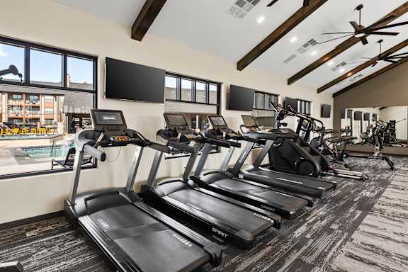 A gym with treadmills and a television.