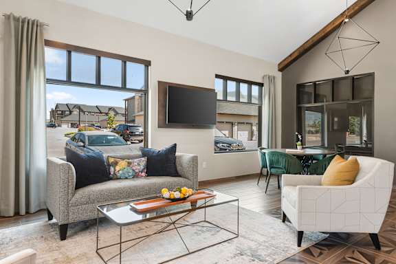 A living room with a grey couch, a coffee table, and a flat screen TV.